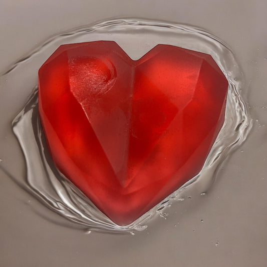 Rose Garden Soap shaped like a red heart, showcasing its luxurious handmade quality and unique design.